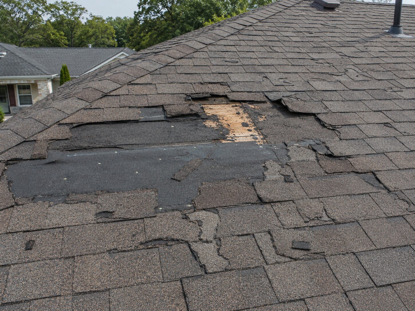 Storm-damaged roof with missing shingles on a home in Atlanta, Georgia